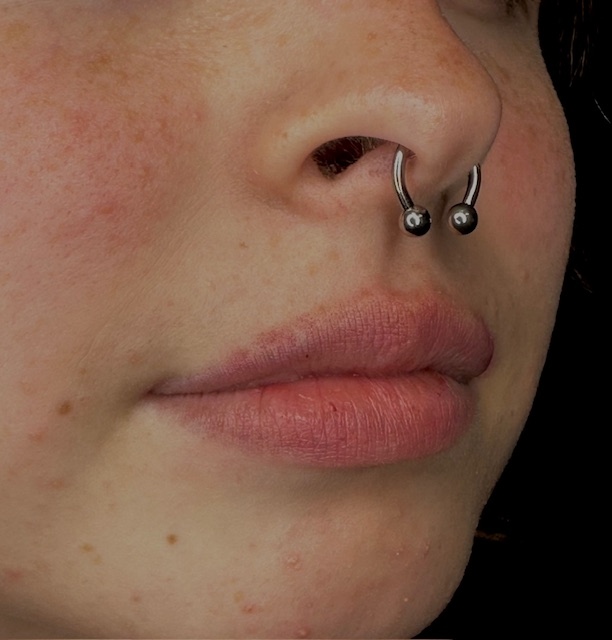 Professional septum piercing with a circular barbell by a Final Touch Tattoo piercer in San Antonio