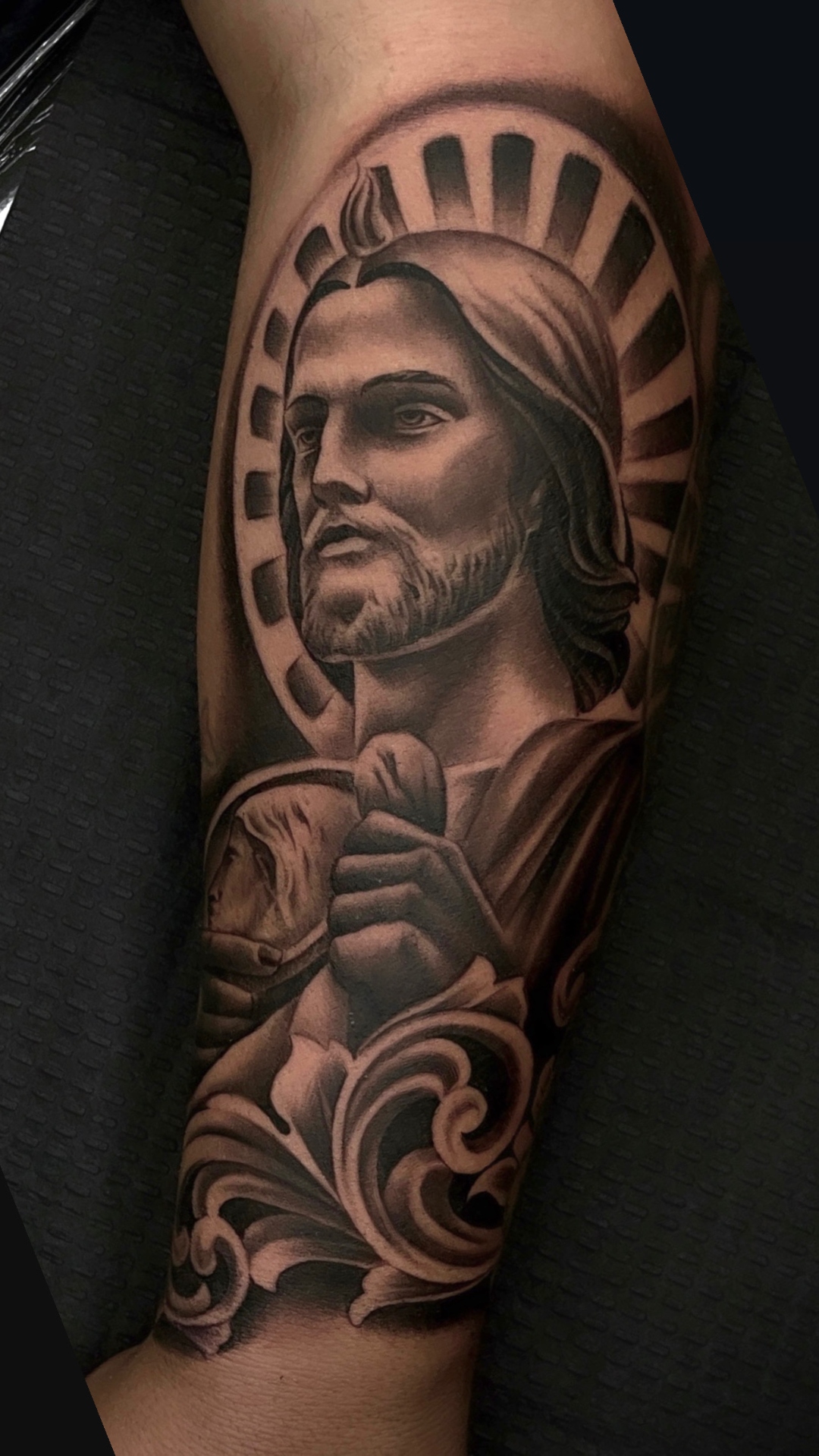 Black and gray realism portrait of a warrior saint with a radiant halo, showing smooth tonal shading
