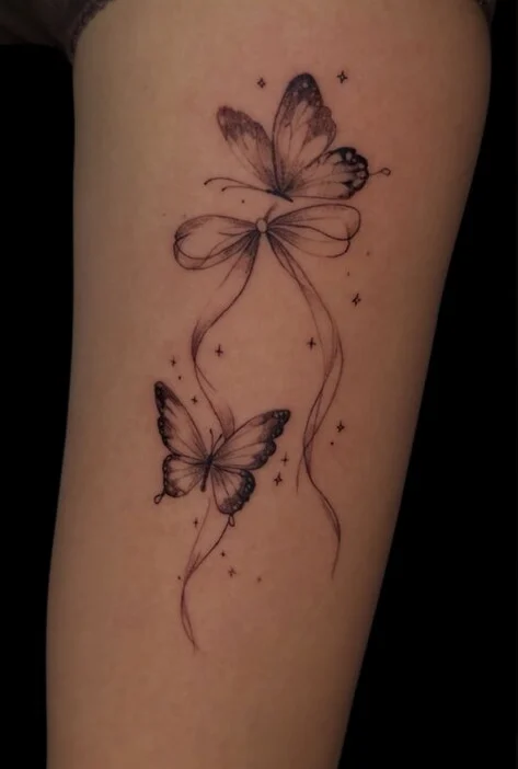 Close-up of a custom fine line butterflies and ribbon tattoo by Justin at Final Touch Tattoo in San Antonio